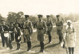 A black and white photograph of uniformed Cadet and adult members of the St John. They are standing formally awaiting a review by royalty in Hyde Park.