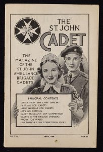 Colour photograph of a black and white magazine cover with an illustration showing a female Nursing Cadet in uniform holding up a placard that lists the contents of the magazine. Behind her stands a male Ambulance Cadet in uniform. The price is shown as sixpence.