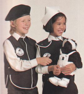 Two young Badgers in their black and white uniform. One of the children is holding a badger mascot, who is dressed in white dungarees.