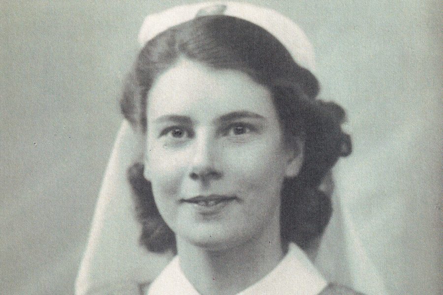 Black and white photograph of a young woman looking directly at the camera. She wears a nursing Cadet uniform including a white nursing cap and white cuffs.
