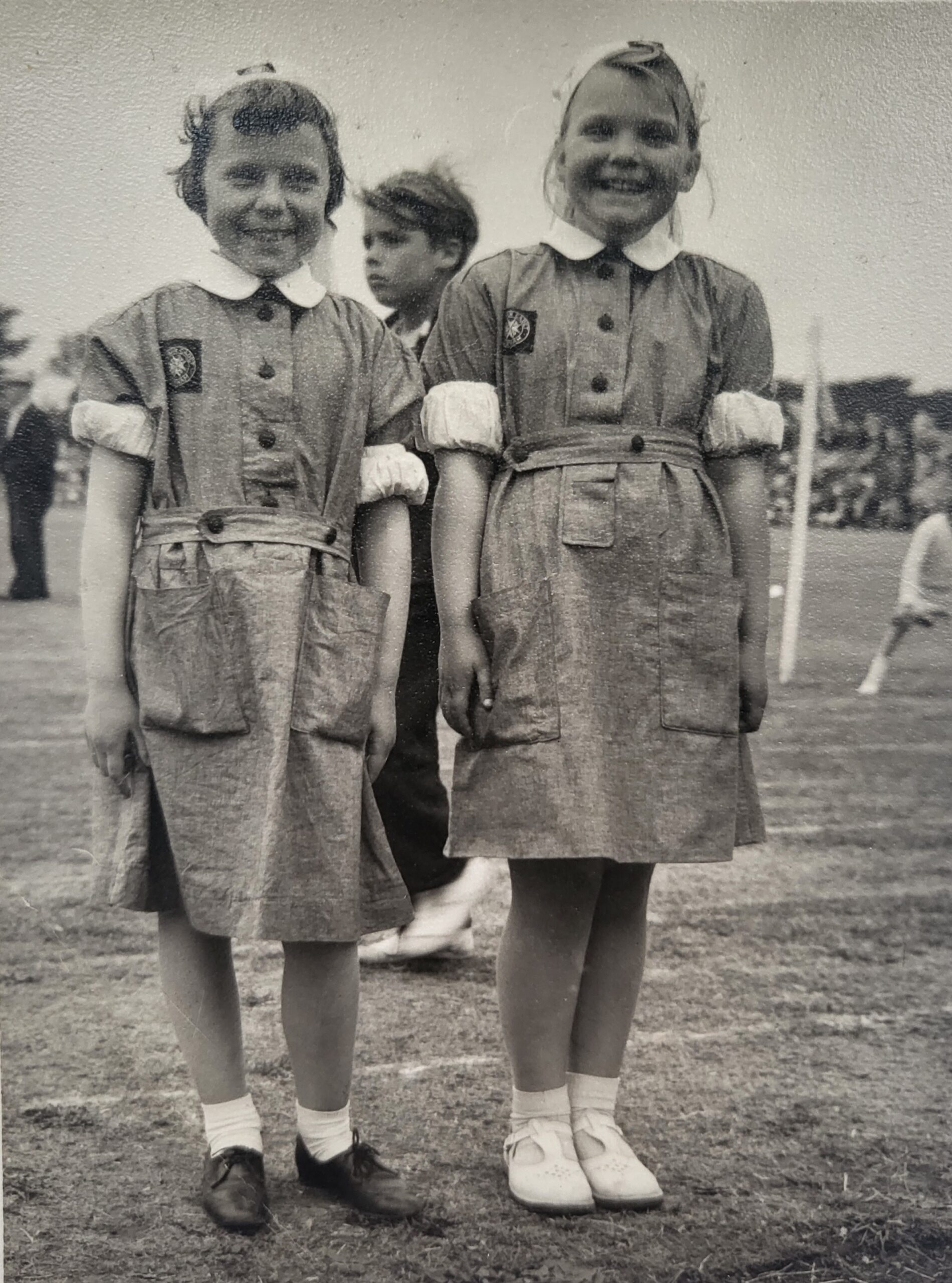 Black and white photograph of two young girl Cadets in uniform standing side by side on a playing field.